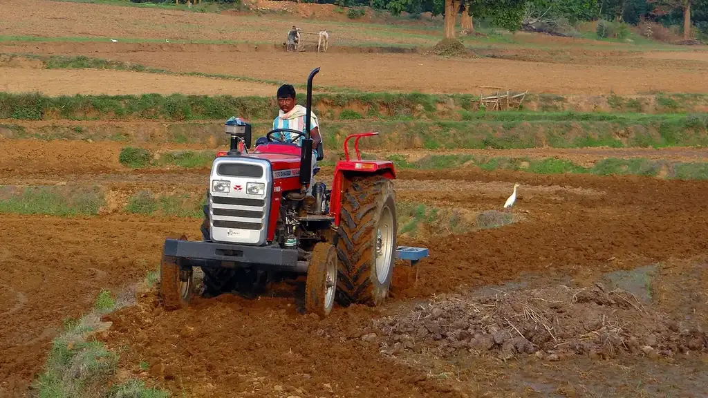 A farmer ploughs his field with a tractor in India