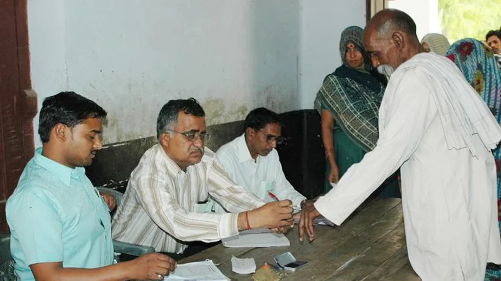 Polling officials attend to a voter at a polling station in Rae Bareli, Uttar Pradesh, during the 2009 general election