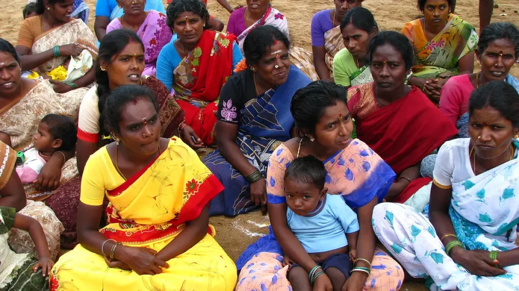 Rural women in colourful saris sitting together at a self-help group meeting in India