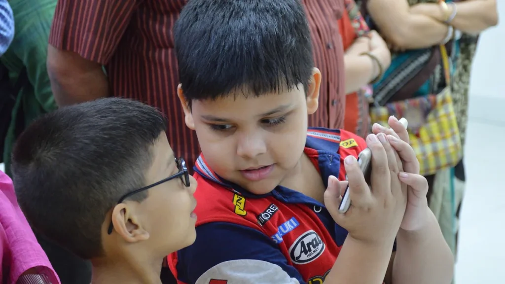 Two young boys looking at a smartphone together