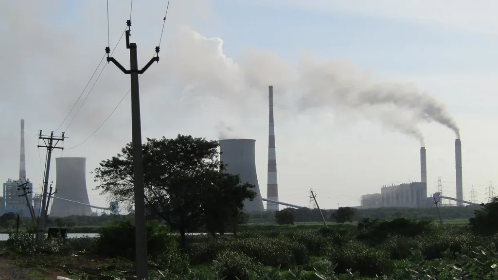Tall chimneys of a thermal power station releasing smoke