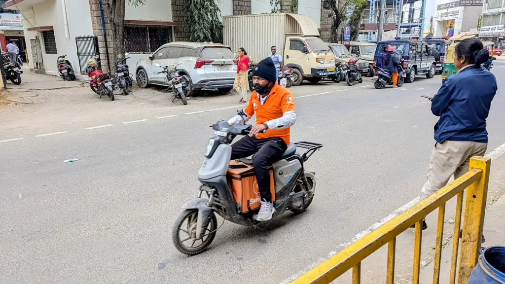 A food delivery rider on a scooter on a city street in Bengaluru