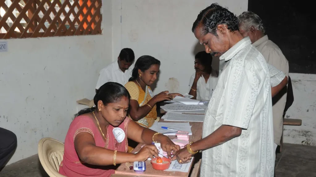 A polling officer marking indelible ink on a voter’s finger at a polling booth in Kanyakumari, Tamil Nadu