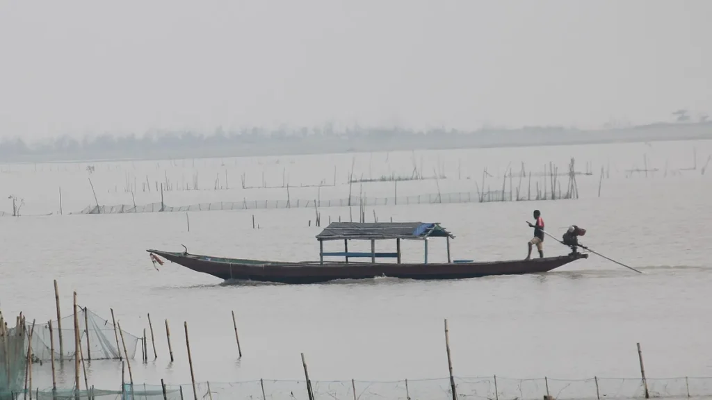 A fisherman poling a boat on Chilika Lake in Odisha, India's first Ramsar site