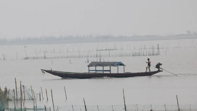 A fisherman poling a boat on Chilika Lake in Odisha, India's first Ramsar site