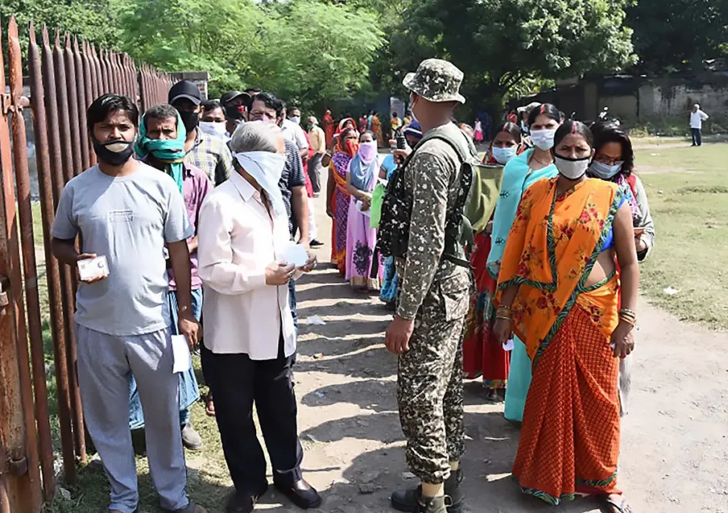 Voters standing in the queue to cast their votes, at a polling booth