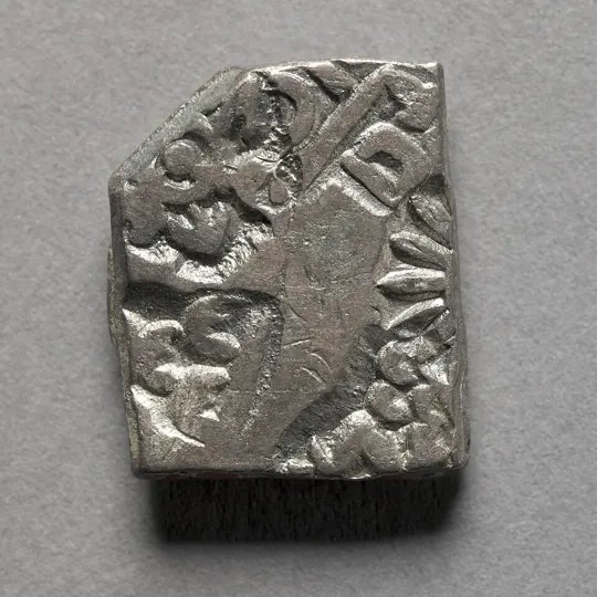 A silver punch-marked coin, about 400 BCE: symbols are punched on, and there is no king's name