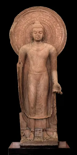 A standing Buddha from Mathura (about 5th century CE). The red sandstone and thin robe are typical of