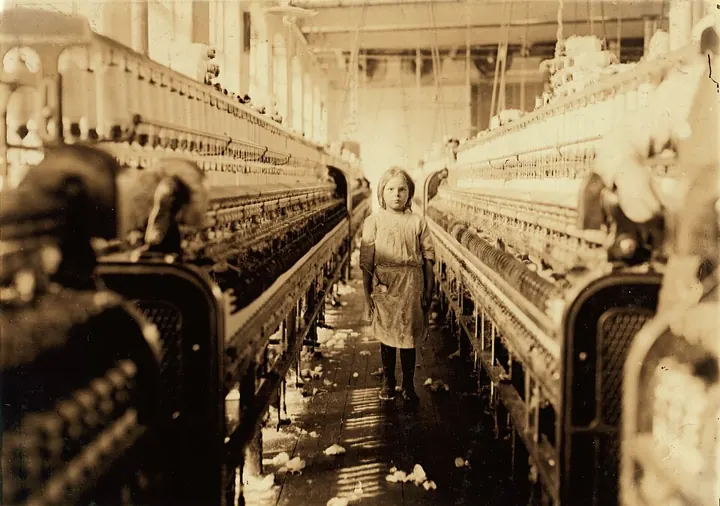 A child spinner in a US cotton mill (1908): child labour followed industry everywhere